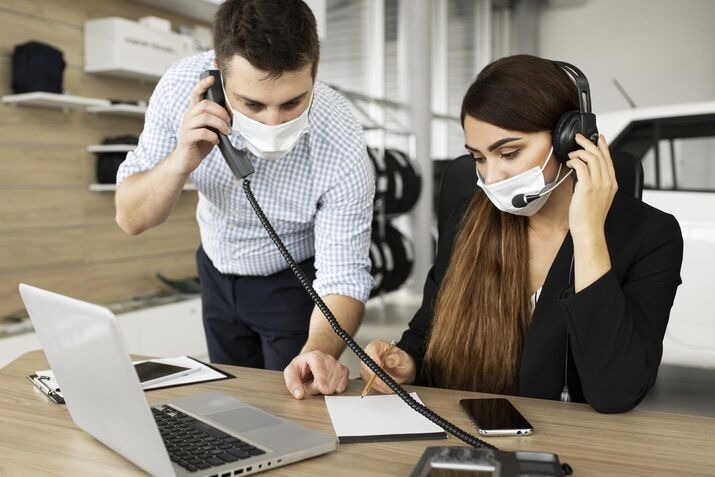 Customer support agents assisting clients through phone and laptop